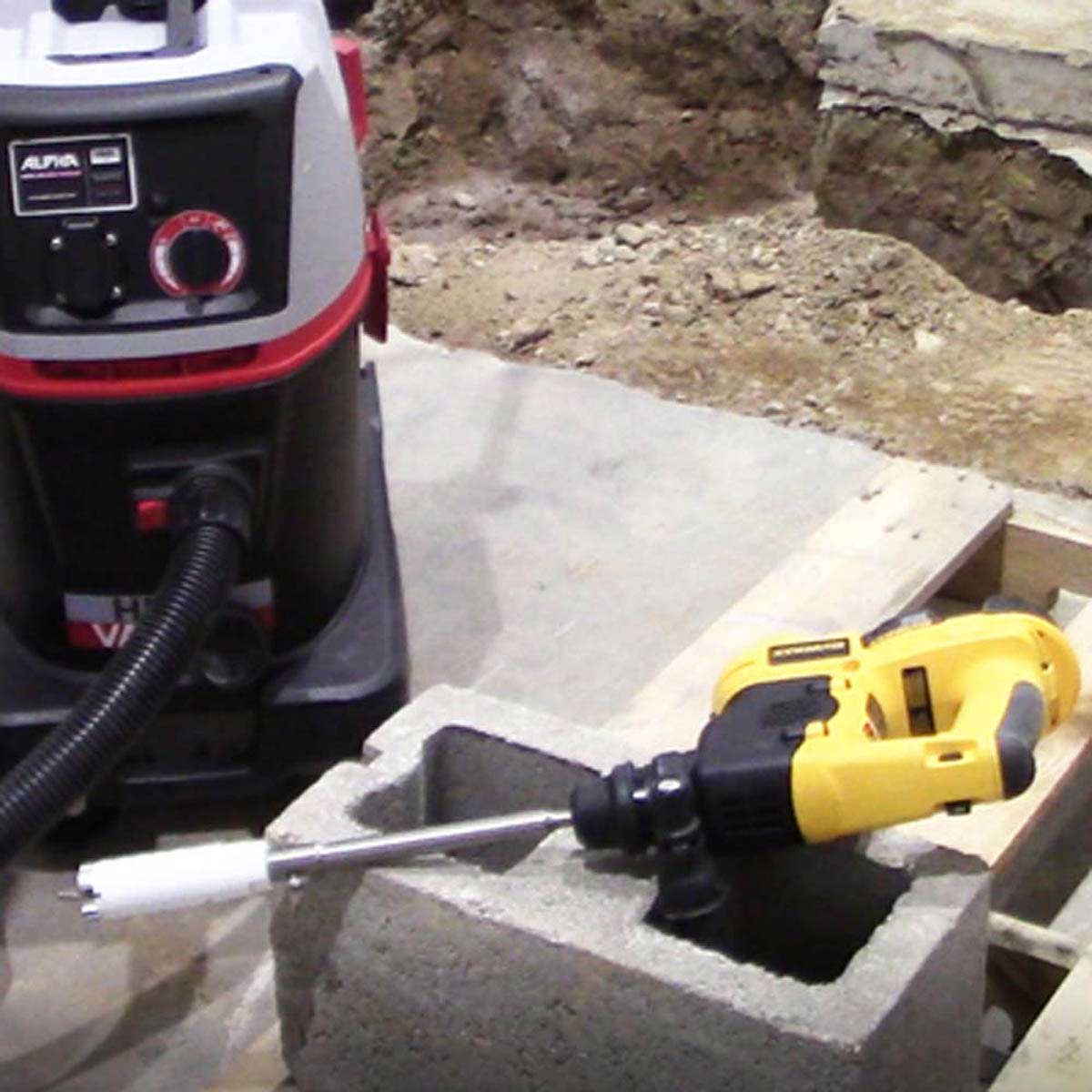 Installer using an Alpha diamond core bit to drill a hard construction surface