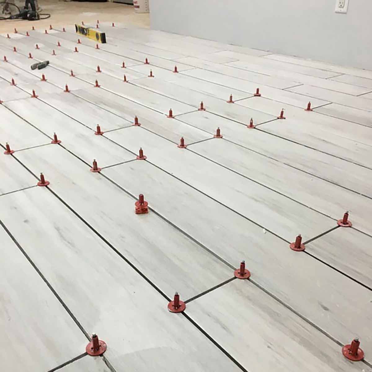 Porcelain white tile with ATR Tile Leveling System T Shape Profile Spacers in a brick Pattern