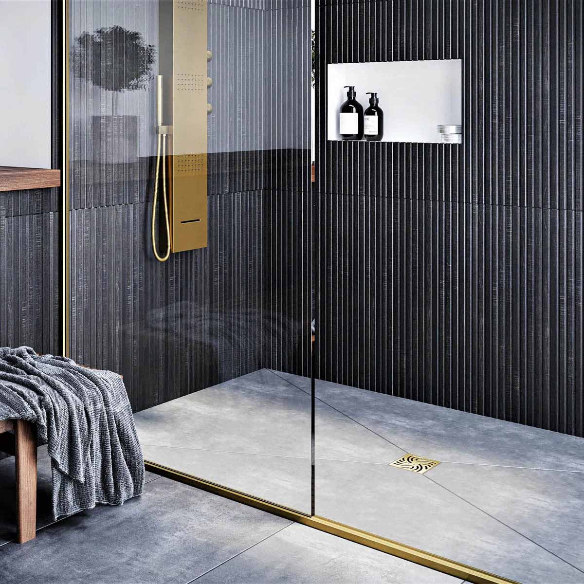 Modern bathroom with glass shower enclosure, black wall tiles, and gold fixtures with Ebbe Drains Unique Square Shower Drain Grate - Twister