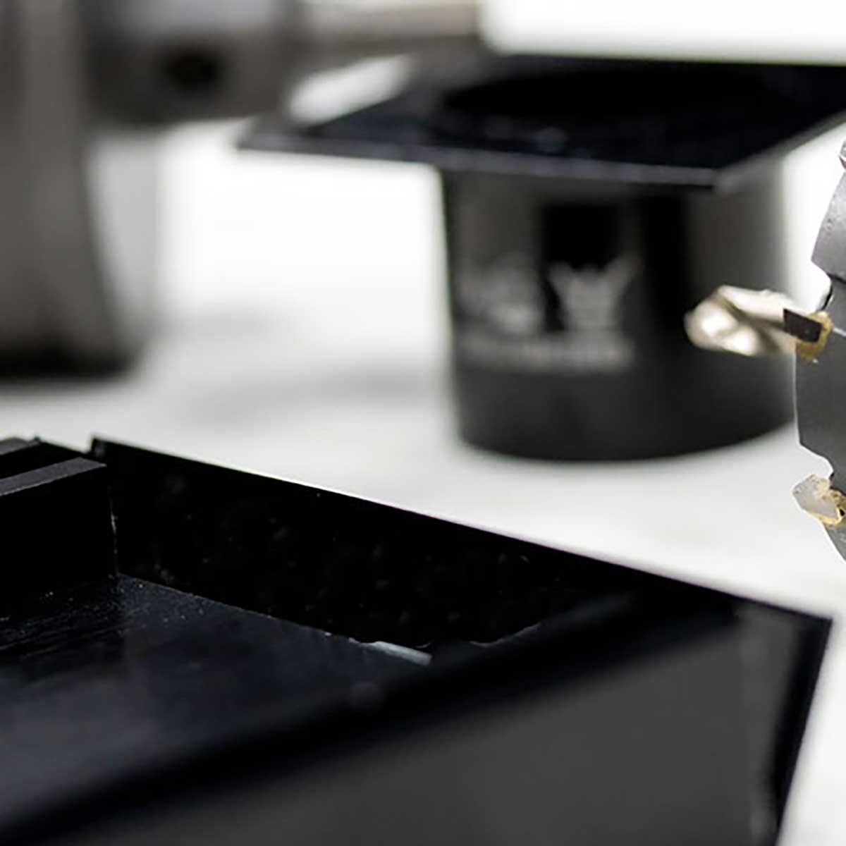 Close-up of a cLauxes Grates Custom Linear Drain End Caps on a kitchen counter