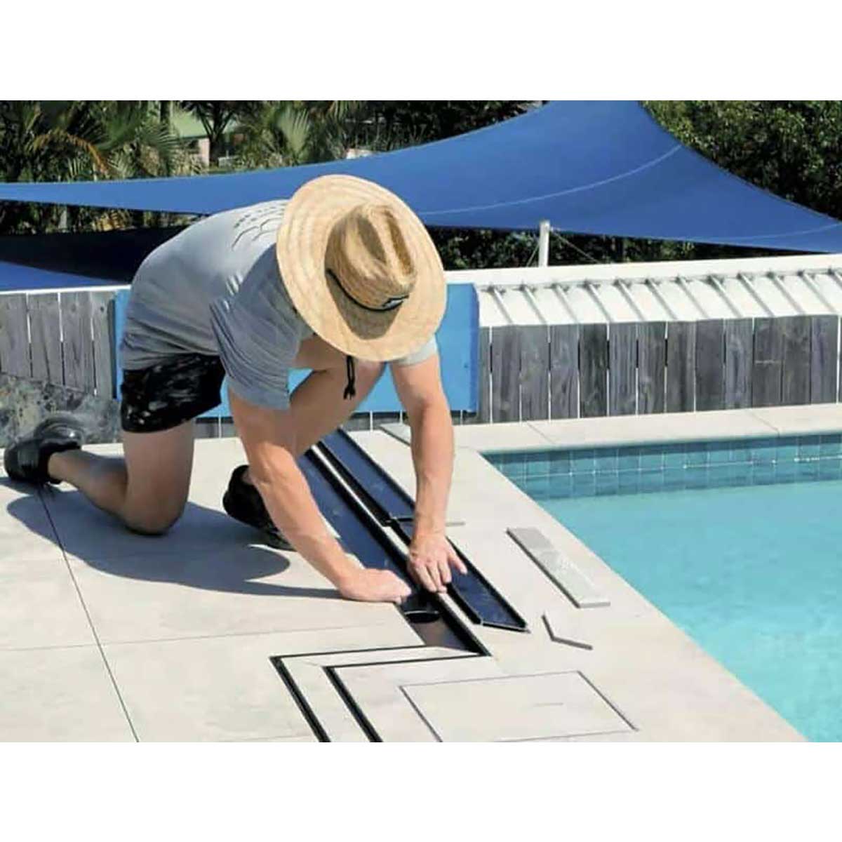Person installing a pool cover on a pool with Close-up of a tiled floor and Lauxes Grates Custom shower drain Tile Insert in Midnight