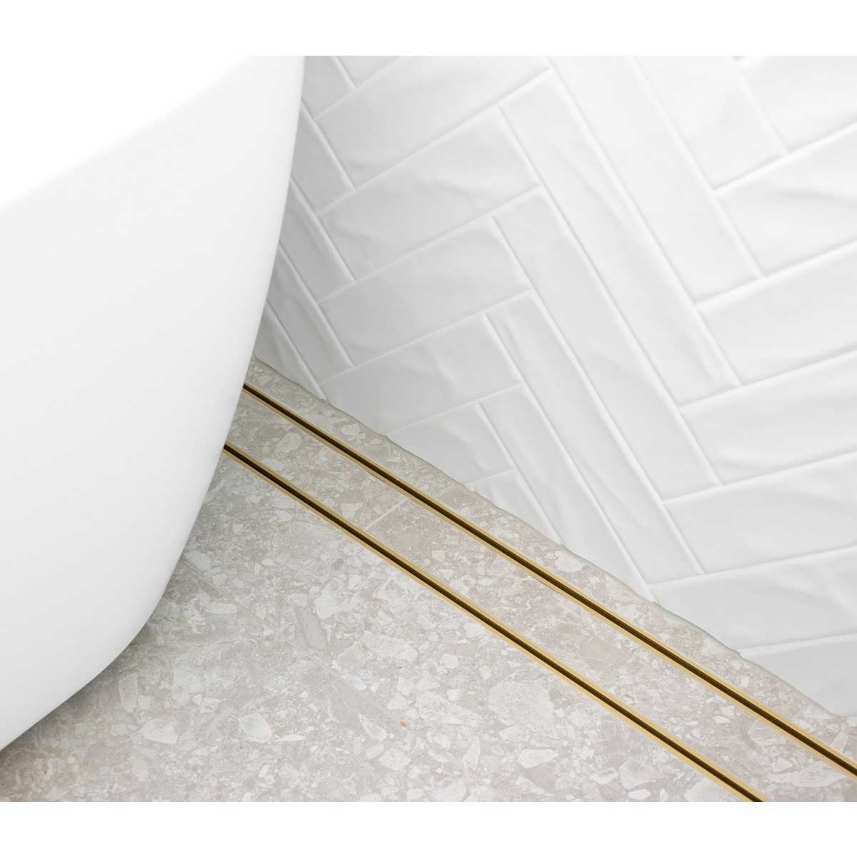 Close-up of a tiled floor with Lauxes Grates Custom shower drain Tile Insert in Matte Gold finish