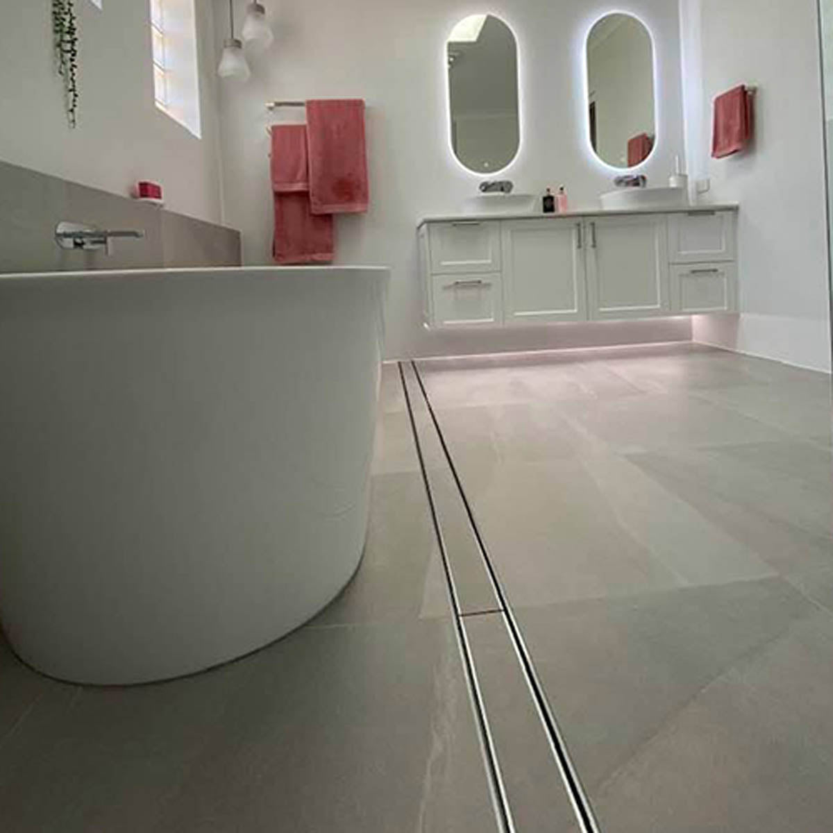 Close-up of a tiled floor with Lauxes Grates Custom shower drain Tile Insert in Silk Silver finish