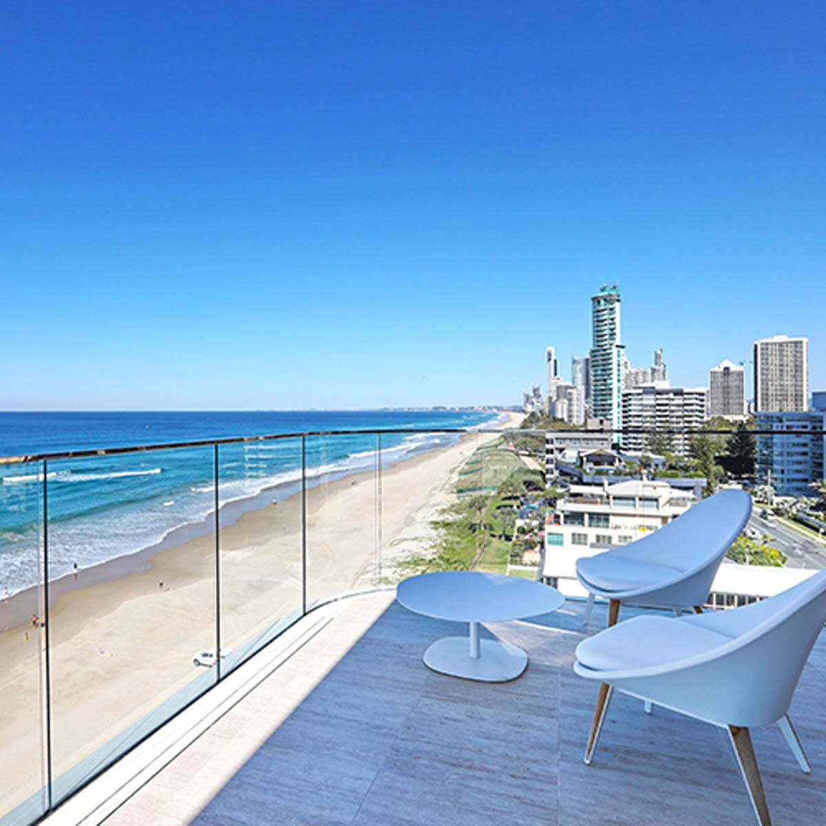 Modern balcony with ocean view and city skyline with Close-up of a tiled floor with Lauxes Grates Custom shower drain Tile Insert in Silk Silver finish installed