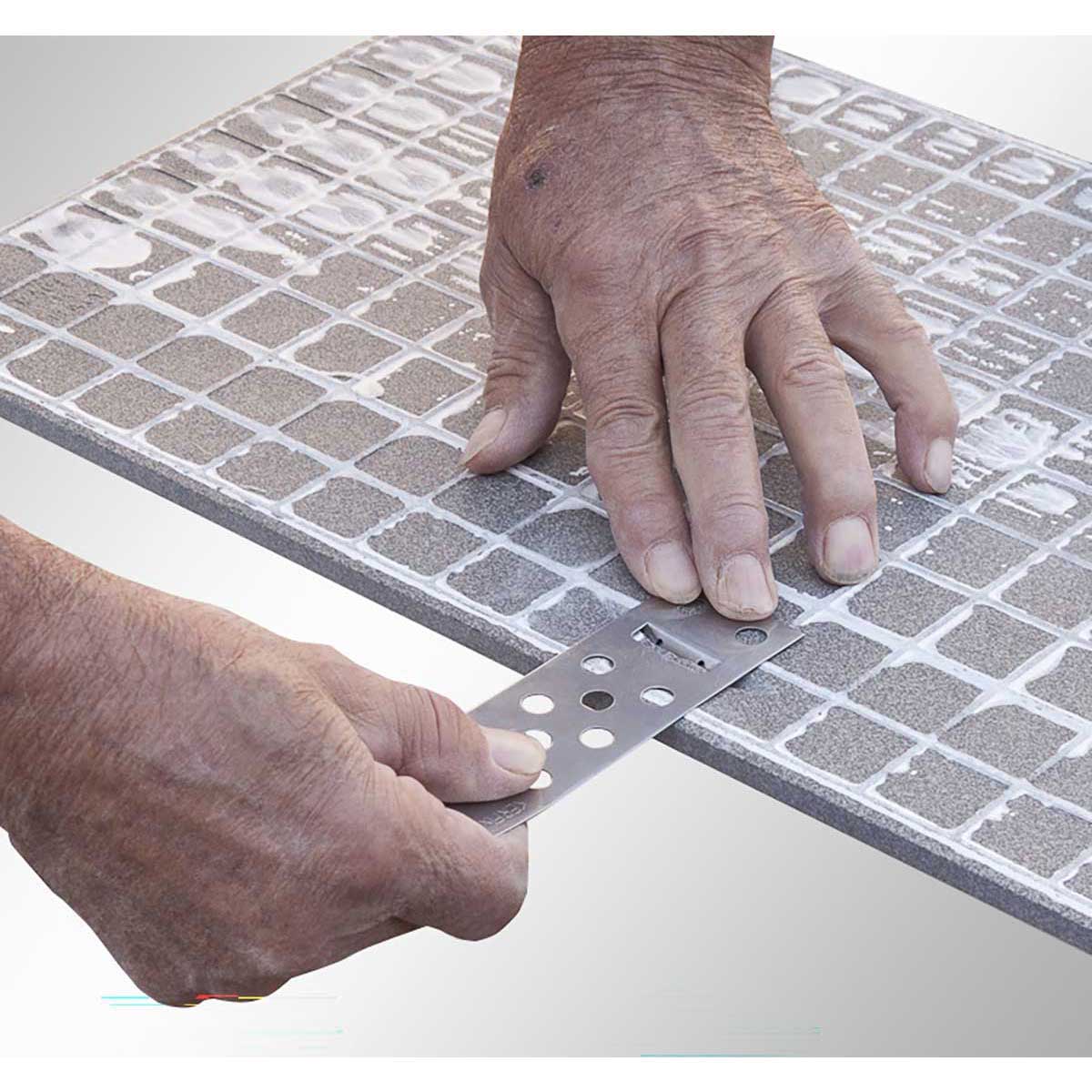 Person using a Rai Fix hook to install large format tile