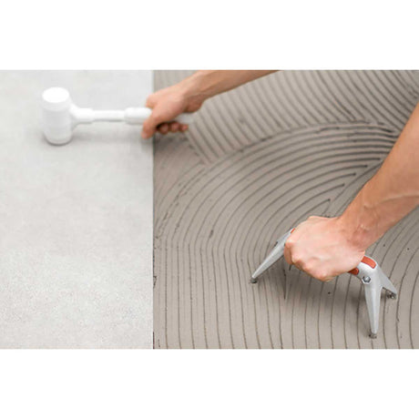 Person using tools to apply and smooth concrete on a floor