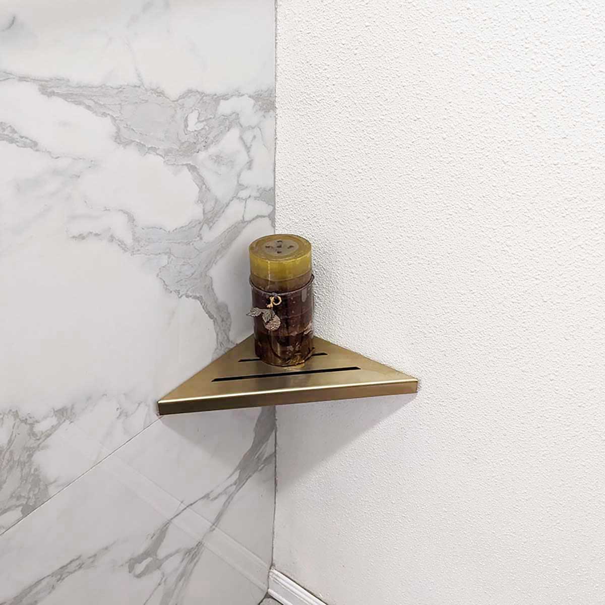 SereneDrains Stainless Steel Satin Gold Corner shower shelf mounted on a marble wall