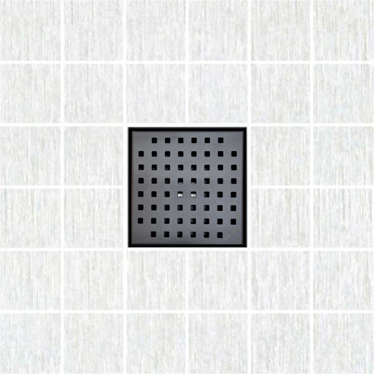 Black square drain cover on a white tiled floor