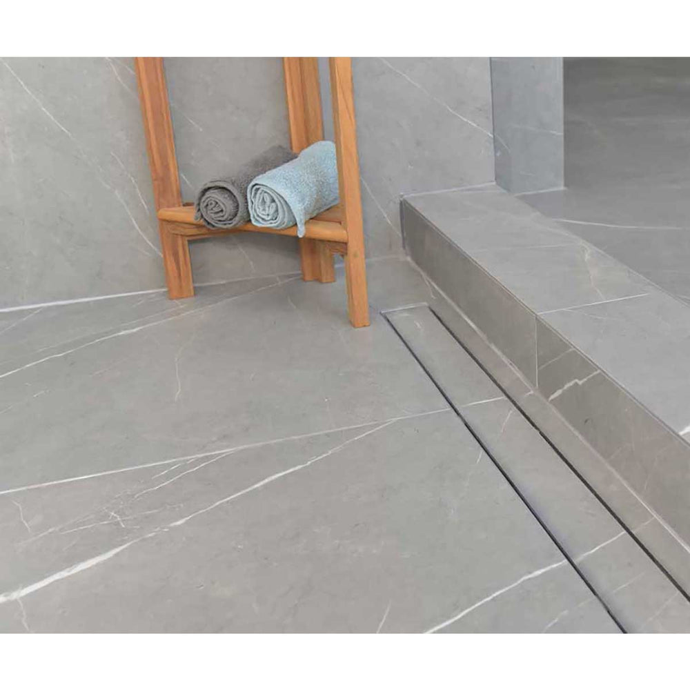 SereneDrains Linear Shower Drain Tile Insert Brushed Nickel over grey porcelain tile with teak bench