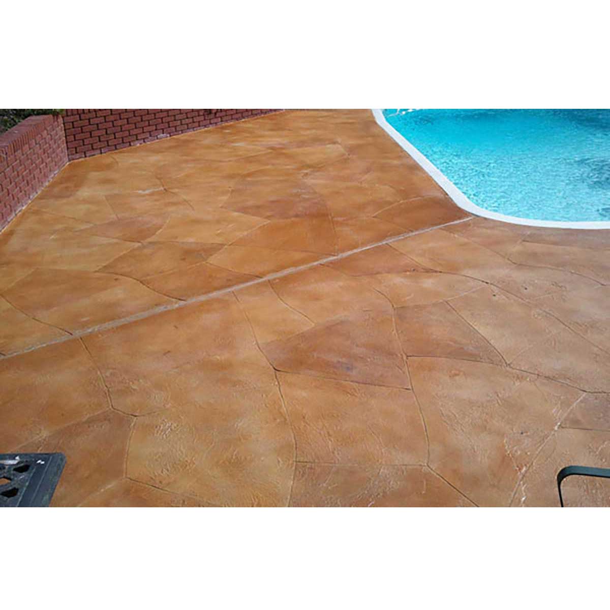 Smith Paint sealer over concrete floor Stained concrete patio next to a pool with a brick wall in the background