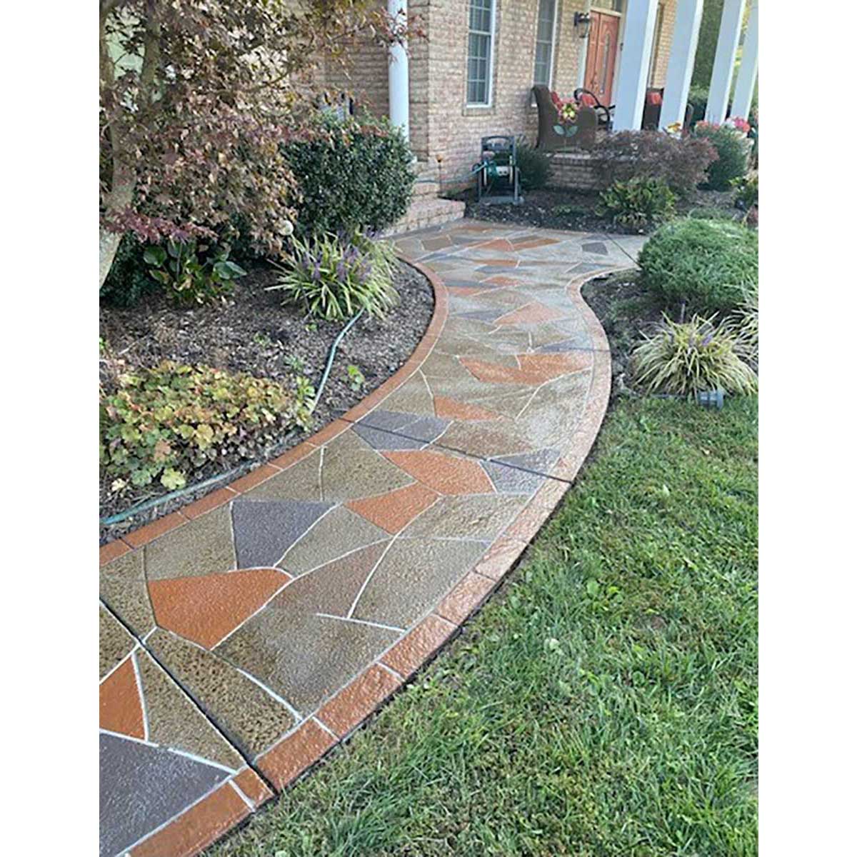 Smith Paint sealer over concrete floor design as a Decorative stone pathway leading to a house with garden plants on either side.