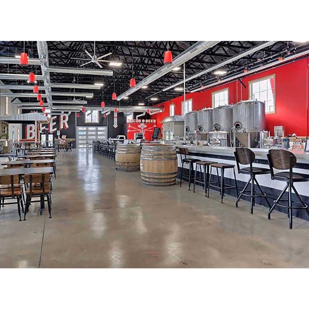 Smith Paint sealer over concrete floor in an Interior of a brewery with beer tanks, tables, and chairs.