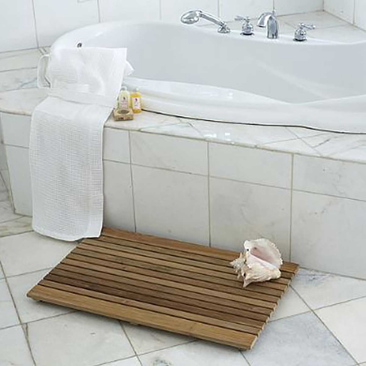 African teak wood mat beside freestanding bathtub