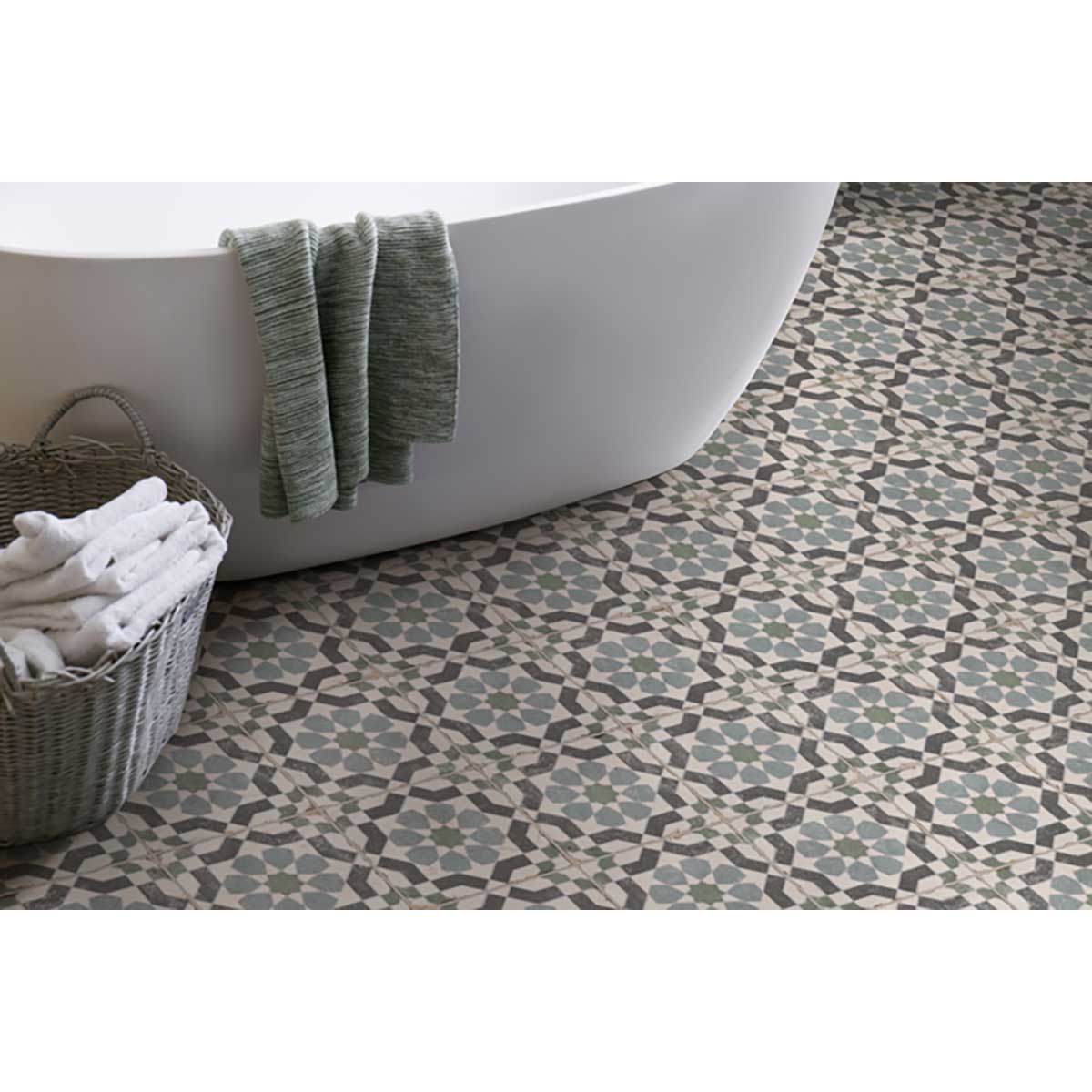 Bathroom with a freestanding bathtub, patterned floor, basket of towels and Alhambra Series Layla 8x8 Deco Porcelain Tile