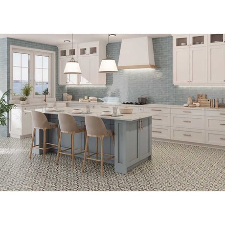 Modern kitchen with a gray island, white cabinets and Alhambra Series Layla 8x8 Deco Porcelain Tile