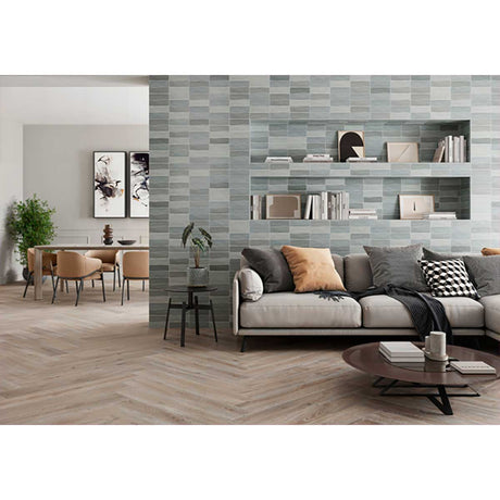 Modern living room with a gray sofa, decorative pillows, and Lago 2.5x8 Matte Ceramic Wall Tile