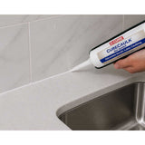 Person applying C-Cure Non Sanded Tile Caulking 10.2 oz to a Kitchen Sink with a Curecaulk tube.