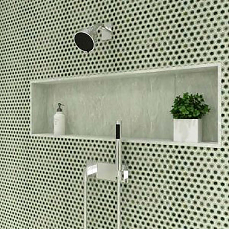 Bathroom setting with a shower head, soap dispenser, and plant against a Hexagon Porcelain Mosaic Tile - Sage Green