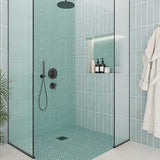 Modern bathroom with Penny Round Porcelain Mosaic Tile - Mint Rose, glass shower enclosure, and bathrobe.