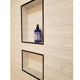 Shower niche with shampoo bottle installed over Cream 3x12 Glossy Ceramic Groove Wall Tile