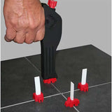 Hand using a DTA tile leveling system tool GUN on a tiled floor