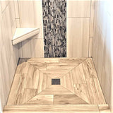 Modern shower with glass door, tiled walls, and a bench with a towel and Ebbe Square Shower Drain Grates