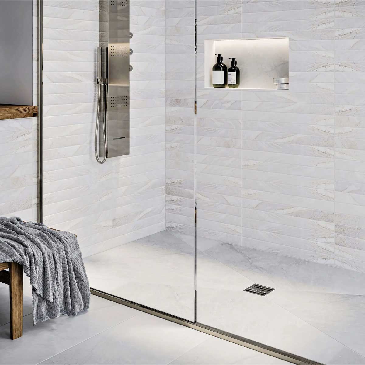 Modern shower with glass door, tiled walls, and a bench with a towel and Ebbe Square Shower Drain Grates