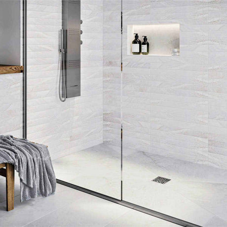 Modern bathroom with glass shower enclosure, White wall tiles, and gold fixtures with Ebbe Drains Unique Square Shower Drain Grate - Bubbles