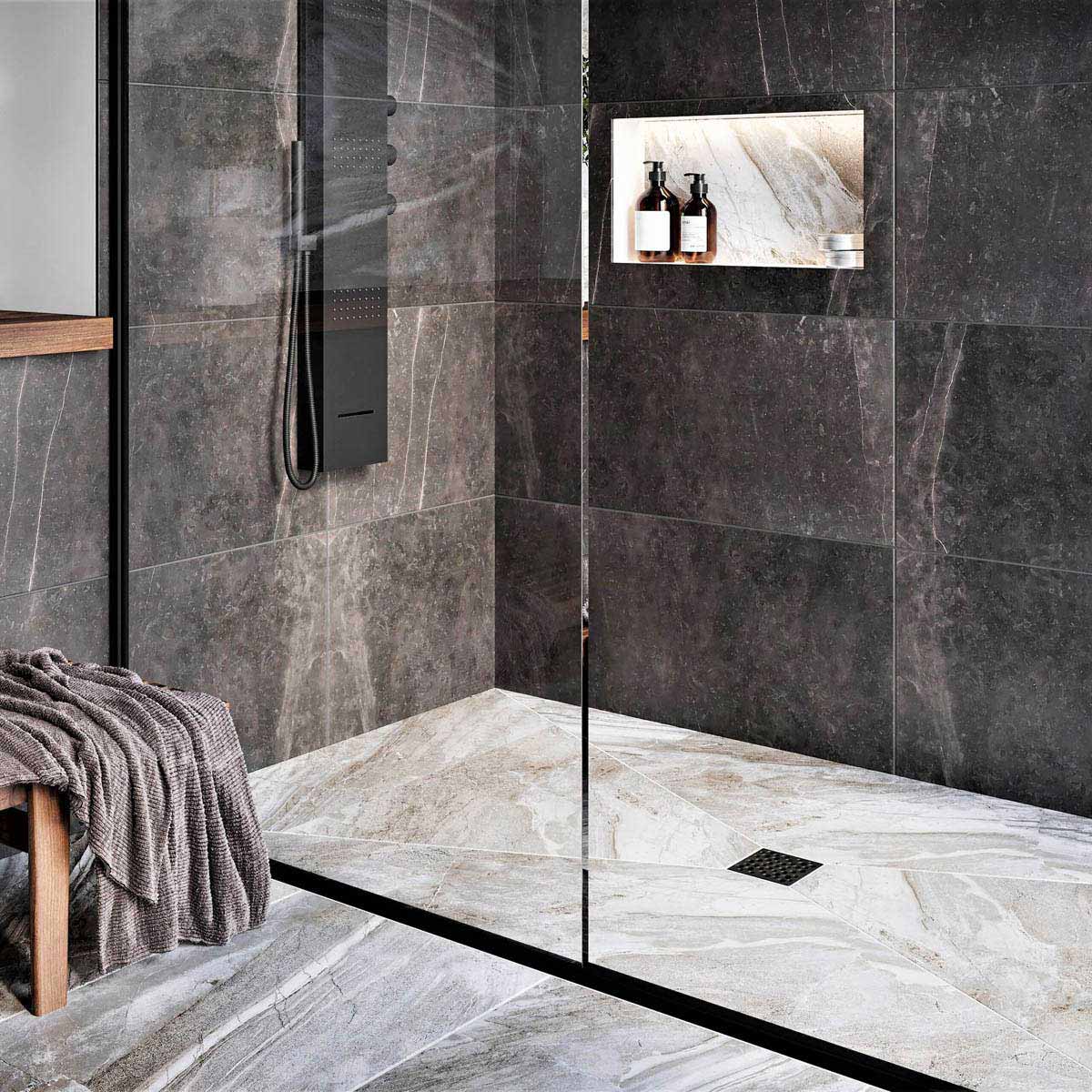 Modern bathroom with glass shower enclosure, black wall tiles, and gold fixtures with Ebbe Drains Unique Square Shower Drain Grate - Bubbles