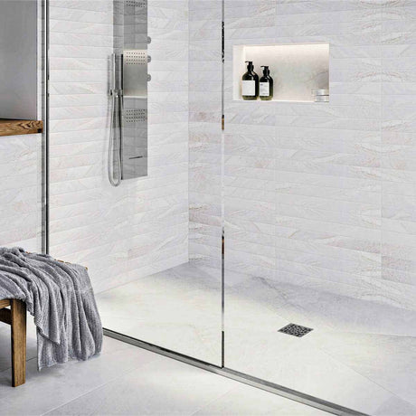 Modern bathroom with glass shower enclosure, White wall tiles, and gold fixtures with Ebbe Drains Unique Square Shower Drain Grate - Bubbles