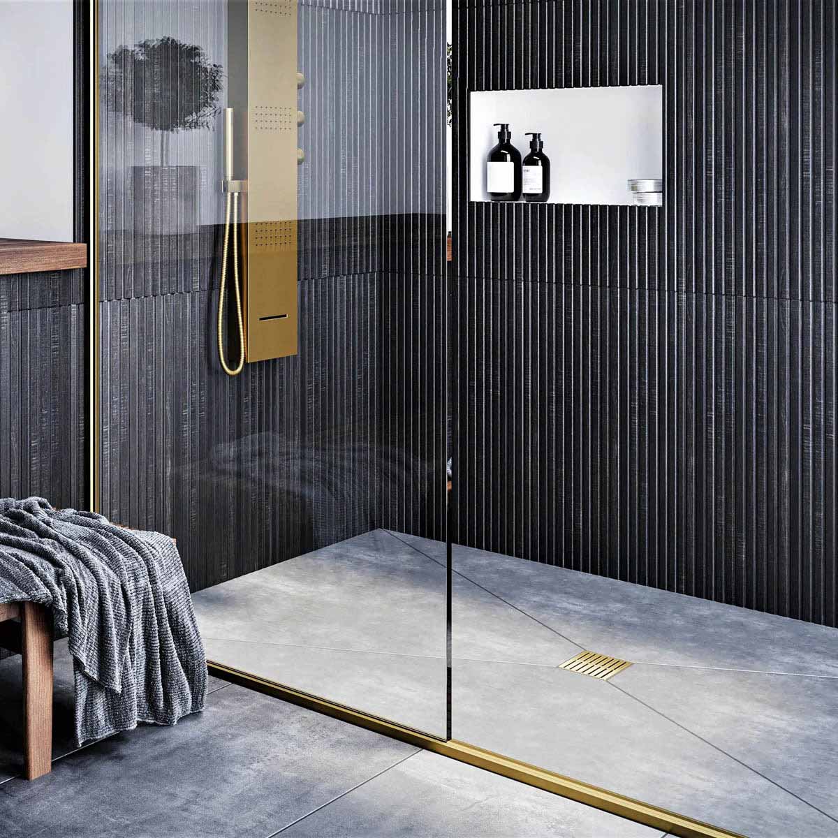 Modern bathroom with glass shower enclosure, black wall tiles, and gold fixtures with Ebbe Drains Unique Square Shower Drain Grate - Parallel