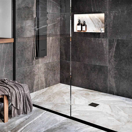 Modern bathroom with glass shower enclosure, black wall tiles, and Black fixtures with Ebbe Drains Unique Square Shower Drain Grate - Parallel