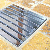 Modern bathroom with glass shower enclosure, White wall tiles, and Brushed Nickel fixtures with Ebbe Drains Unique Square Shower Drain Grate - Parallel on a stone pavement