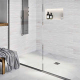 Modern bathroom with glass shower enclosure, White wall tiles, and Brushed Nickel fixtures with Ebbe Drains Unique Square Shower Drain Grate - Splash