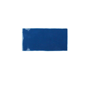 Glossy indigo ceramic subway tile featuring handcrafted Spanish artisan texture