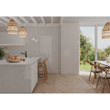 Modern kitchen with white island, wooden chairs, and Kaleidoscope 3x6 Handmade Ceramic Subway Tile - Light Grey Glossy Spanish Wall Tile