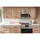 Modern kitchen with wooden cabinets, stainless steel appliances, and Kaleidoscope 3x6 Handmade Ceramic Subway Tile - Light Grey Glossy Spanish Wall Tile