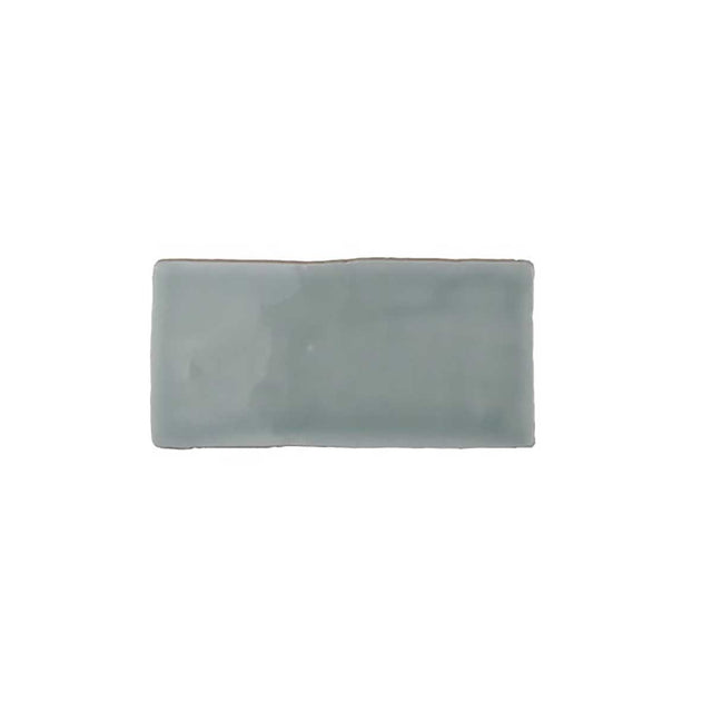 Glossy mint ceramic subway tile featuring handcrafted Spanish artisan texture