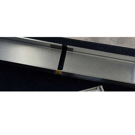 Close-up of a Lauxes Grates Custom Linear Drain Silver with a 180 Degree Joiners insert