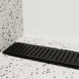 Lauxes Grates Custom Linear Shower Drain NeXT Generation Midnight Black on a terrazzo-patterned floor