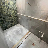 Lauxes Grates Custom Linear Shower Drain NeXT Generation - Matte Gold Installed in a walk in shower