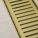 Lauxes Grates Custom Linear Shower Drain NeXT Generation - Matte Gold on a tiled floor