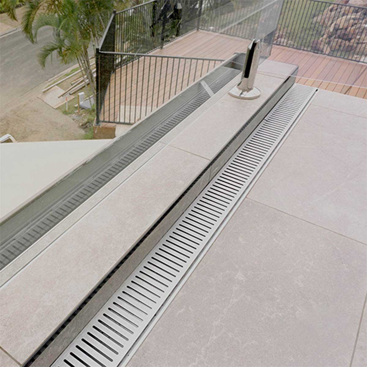Outdoor deck with a Lauxes Grates Custom Linear shower Drain NeXT Generation - Silk Silver
