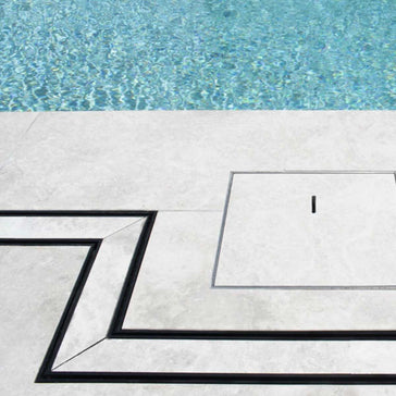 Close-up of a tiled floor with Lauxes Grates Custom shower drain Tile Insert in Midnight Black around the pool
