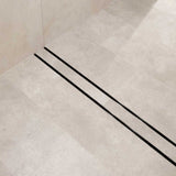 Close-up of a tiled floor with Lauxes Grates Custom shower drain Tile Insert in Midnight Black