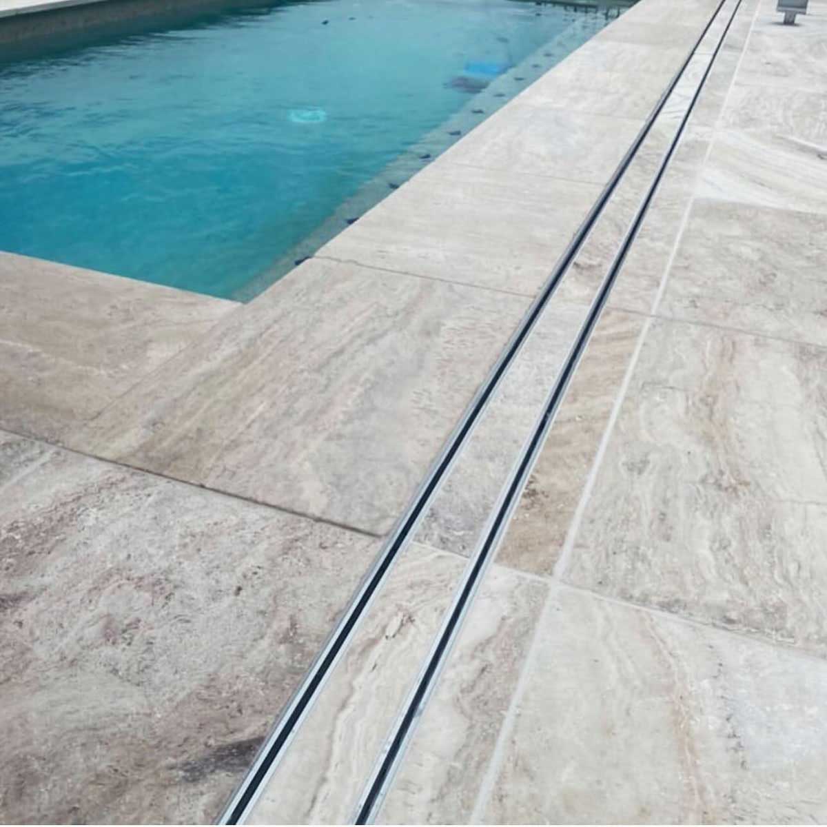 Close-up of a tiled floor with Lauxes Grates Custom shower drain Tile Insert in Silk Silver finish 