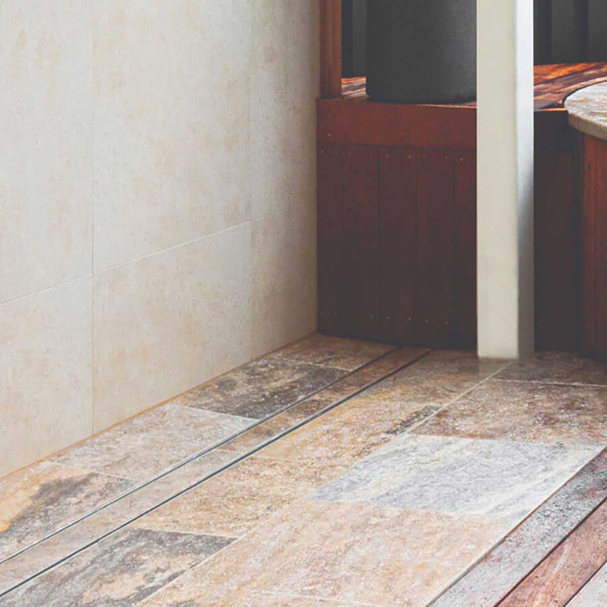 Close-up of a tiled floor with Lauxes Grates Custom shower drain Tile Insert in Silk Silver finish 