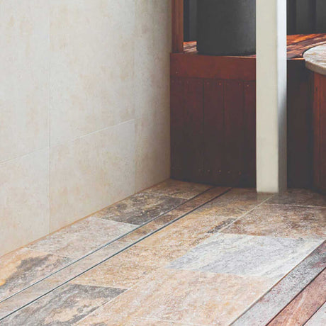 Close-up of a tiled floor with Lauxes Grates Custom shower drain Tile Insert in Silk Silver finish 