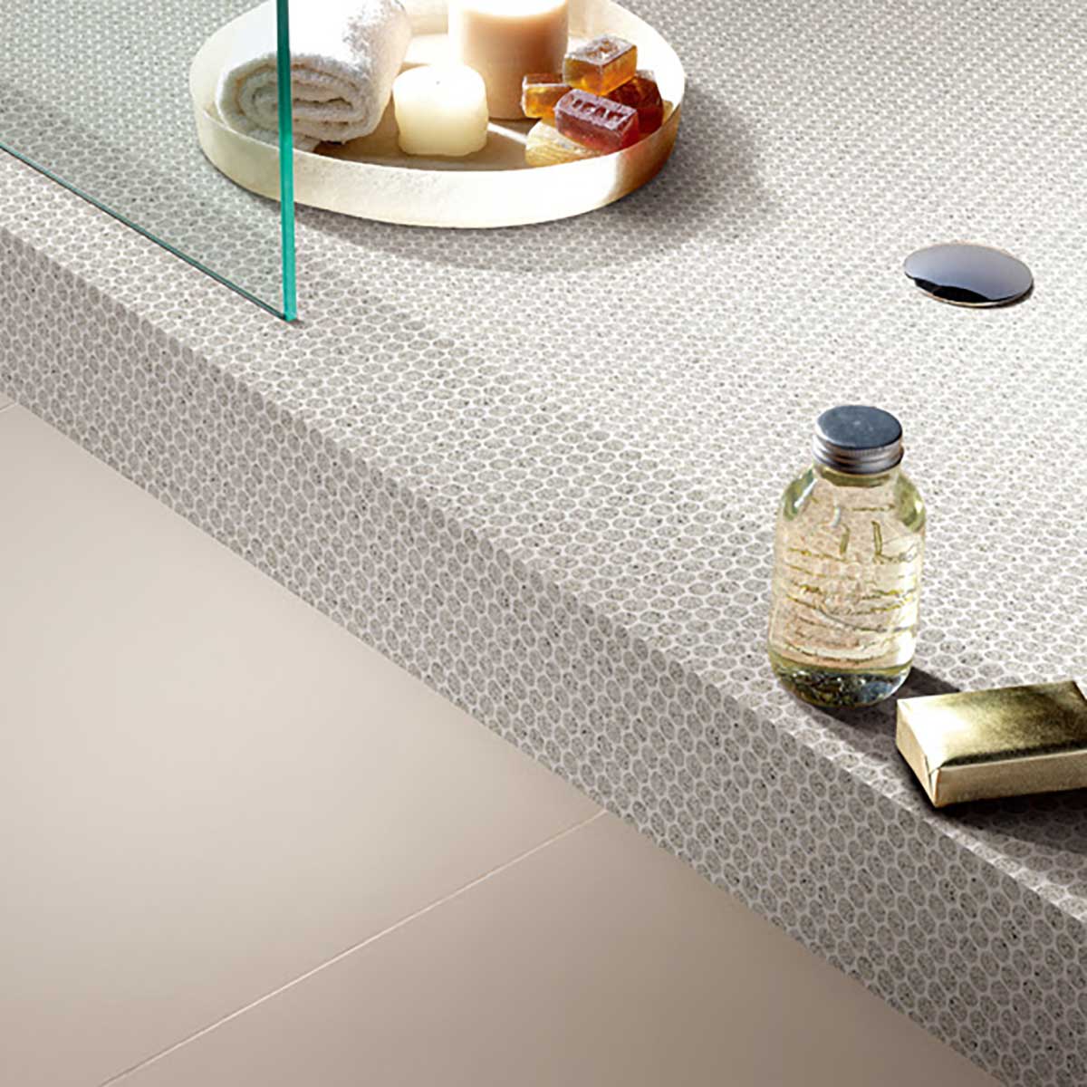 Bathroom counter with decorative elements including a bottle, candles, and Terrazzo Penny Round Mosaic.