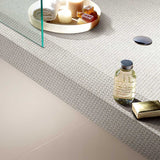 Bathroom counter with decorative elements including a bottle, candles, and Terrazzo Penny Round Mosaic.